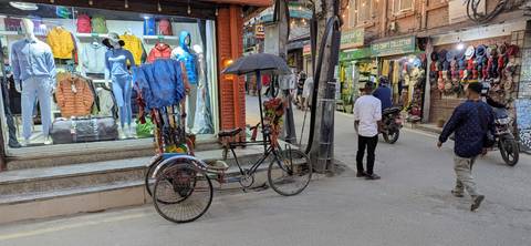 Street with shops and a decorative rickshaw.