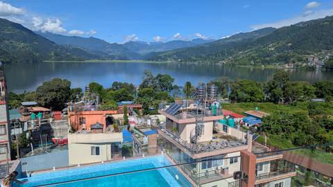 Scenic view over a lake and mountains with a pool in the foreground.