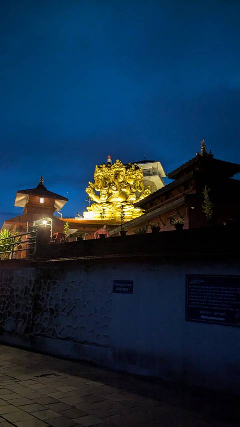 Illuminated statue and buildings at night.