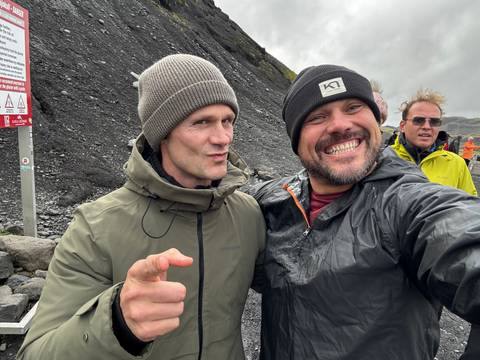 Group of people in outdoor adventure gear smiling at camera.