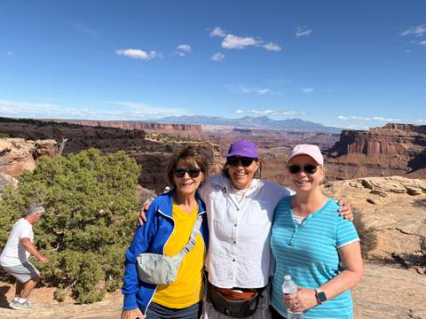Three women with canyon views in the background.
