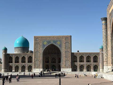 People exploring a grand building with intricate designs.