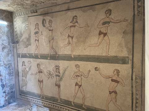 Ancient mosaic depicting people in historical clothing.