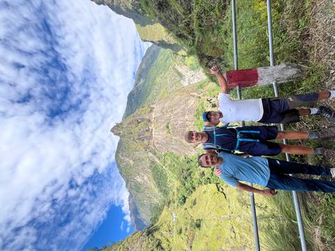 Three hikers posing with a mountainous backdrop in Nepal.