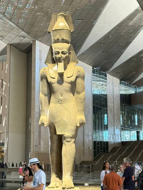 Statue of an ancient Egyptian pharaoh inside a modern building.