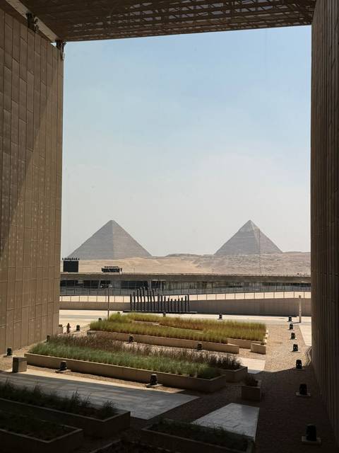 View of pyramids through large modern windows.