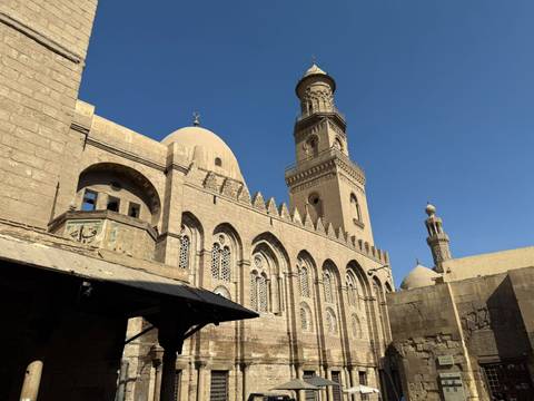 Dome and towers of an ancient mosque against clear sky.
