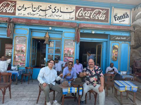 Group of people sitting at a colorful outdoor café.