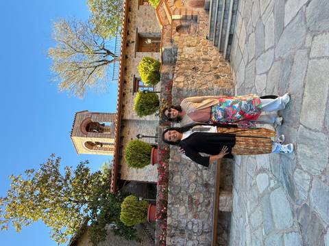 Two people posing in front of a bell tower.