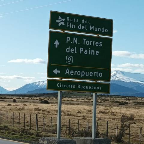 Sign for Torres del Paine National Park with distant mountains.