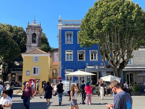 Busy street scene with colorful buildings and people walking around.