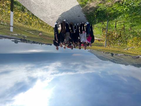 Group of people posing in front of a scenic vineyard with a lake view.