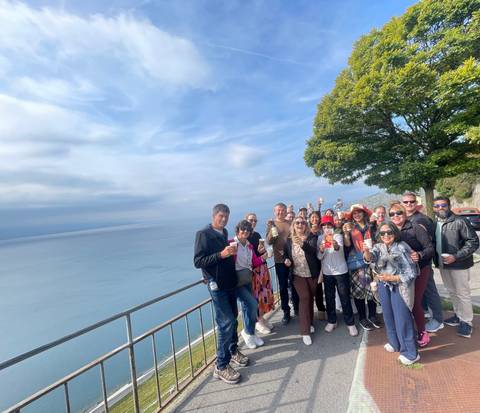 Group of people celebrating with drinks overlooking a lake.