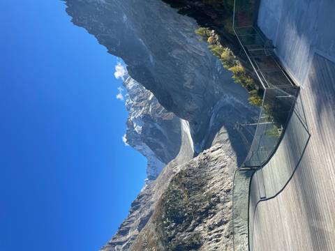 Scenic view of mountains and a glacier under a blue sky.