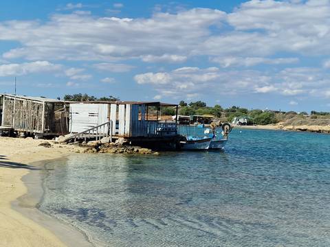 Beach with small boats and huts.