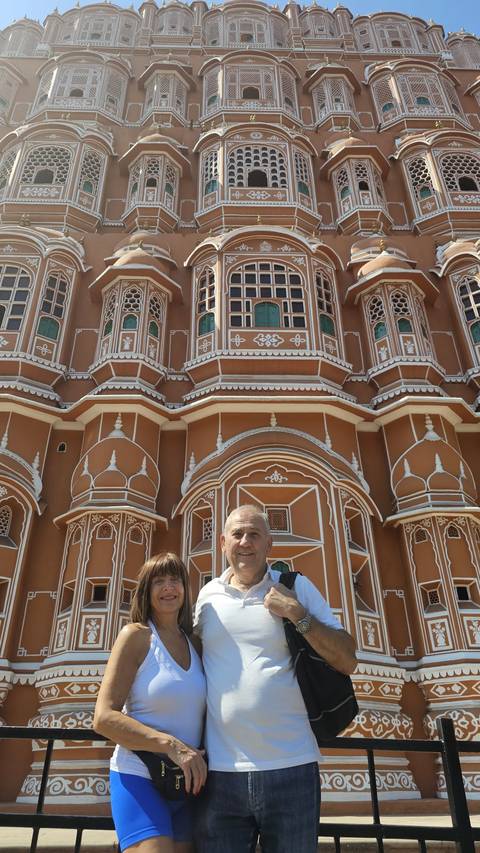 Tourist posing in front of a historic pink palace.