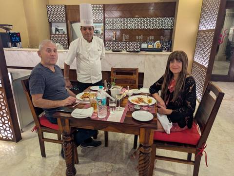 Two people dining in a restaurant with a chef.