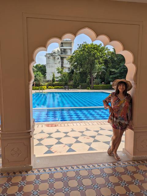 Woman posing by a pool in a resort.