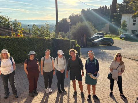 A group of people outdoors with a hilly landscape in the background.