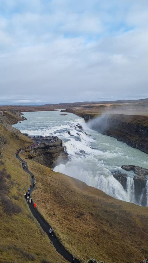Large waterfall with people on the viewing platform.