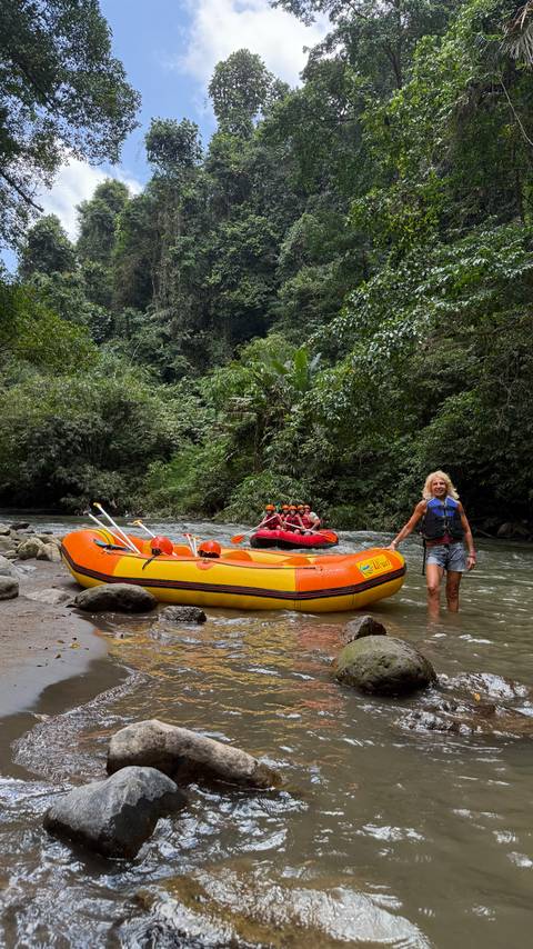 People rafting on a river surrounded by dense jungle.