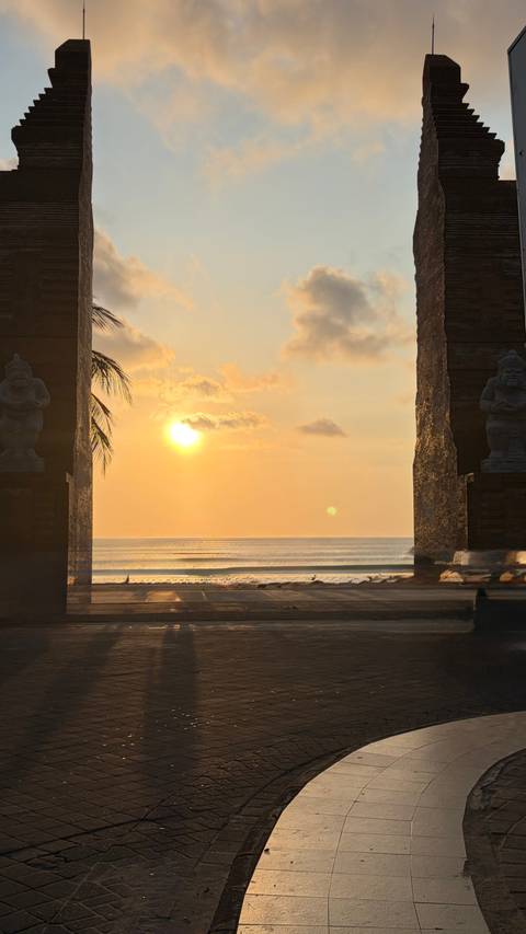 Orange sunset view across the ocean framed by gates.