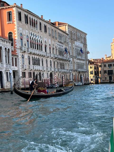 Gondola navigating a canal with historic buildings.