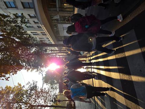 Silhouetted group of people walking with sun in the background.