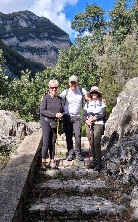 Three hikers standing on a rocky trail.