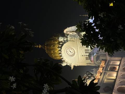 Clock tower with a golden dome at night.