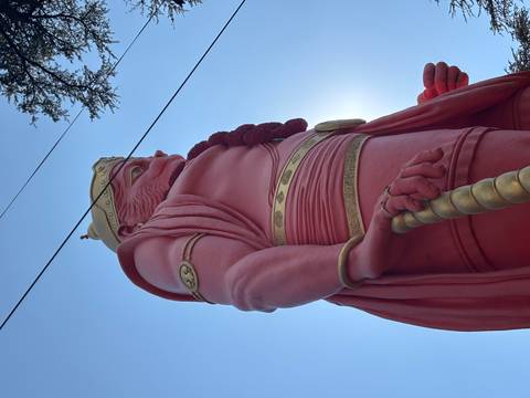 Close-up of a large red statue with a blue sky background.