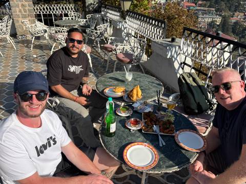 Three people enjoying a meal at an outdoor restaurant.