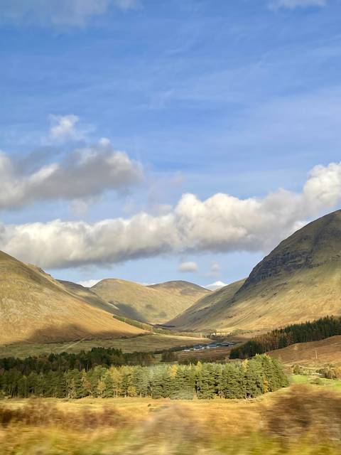 View of a mountainous landscape under a blue sky.