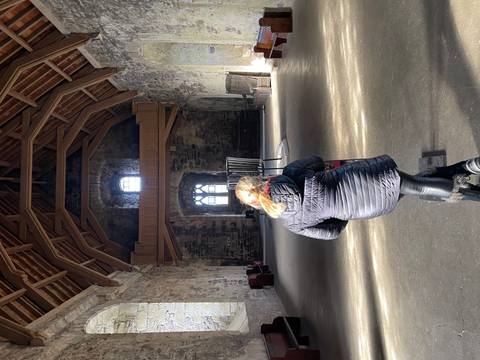 Interior of an ancient stone building with a person standing in the foreground.