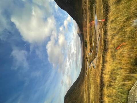 Scenic view of a valley with a winding river and mountains in the distance.