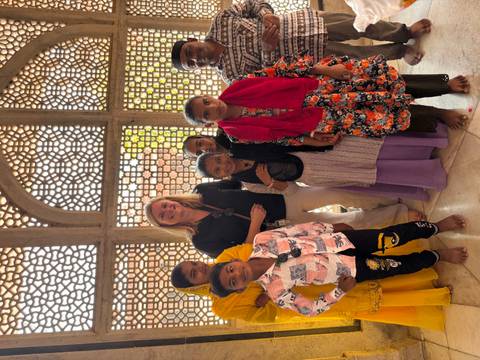 Person posing with local children in traditional clothing.
