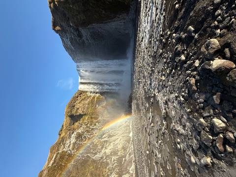 Large waterfall with a rainbow and spray.