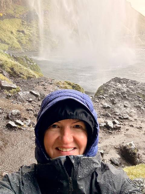 Close-up of a woman's face with a misty landscape in the background.