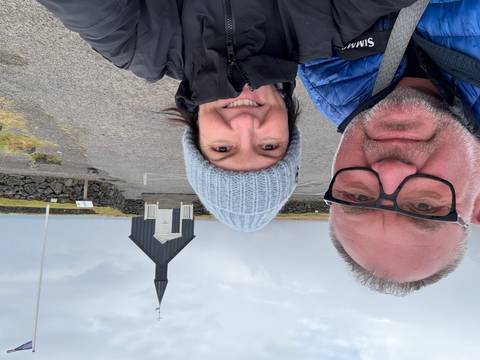 Couple posing in front of a black church in Iceland.