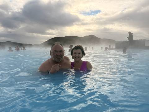 Couple enjoying a warm lagoon with steam rising around them.