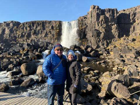Couple posing in front of a waterfall in Iceland.
