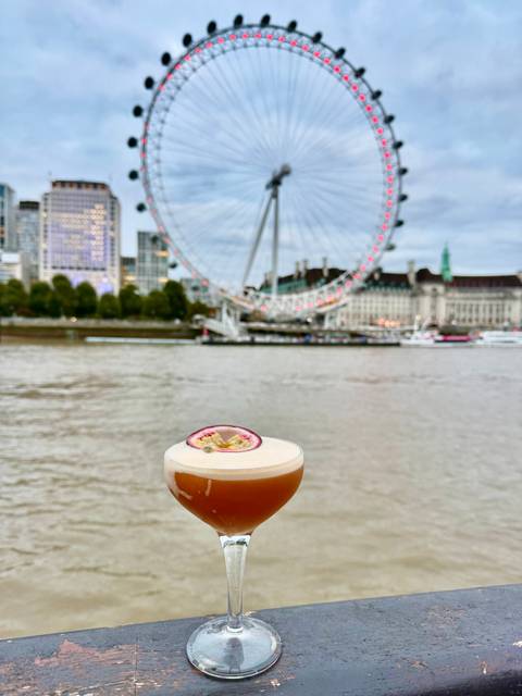 A drink with an iconic Ferris wheel by the river.