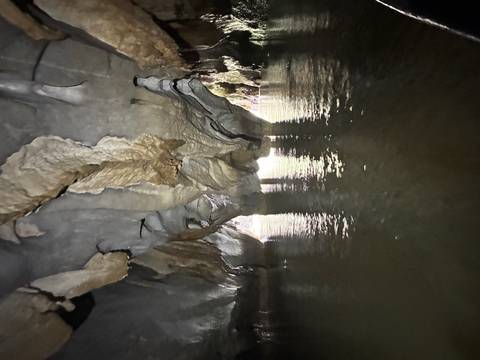 Underground river cave with rock formations.