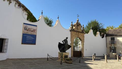 Historical entryway with a statue and informative board.