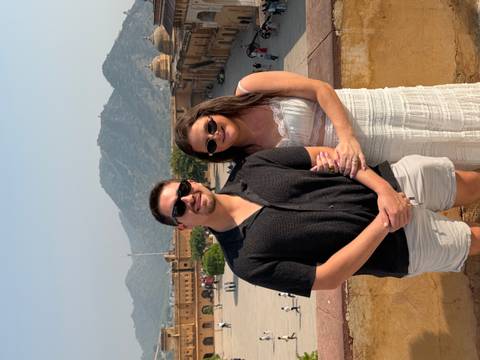 Couple posing in a fort with mountains in the background.