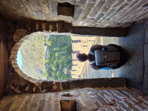 Person sitting at an archway on the Great Wall of China.