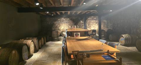 Interior of a distillery with wooden barrels and table.