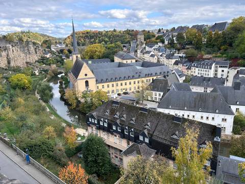A picturesque town with a river running through, surrounded by trees.