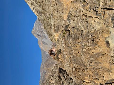 Small shrine on a rocky cliff against a blue sky.