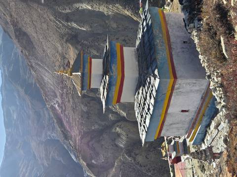 Buddhist stupa overlooking a mountainous landscape.